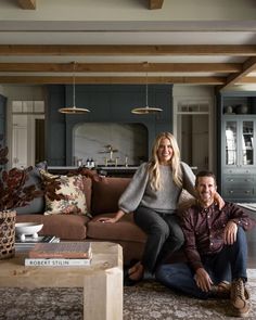 a man and woman sitting on a couch in a living room