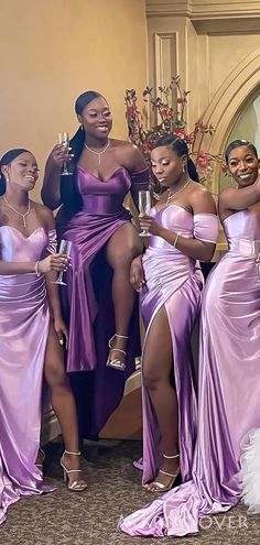 four women in purple dresses posing for the camera