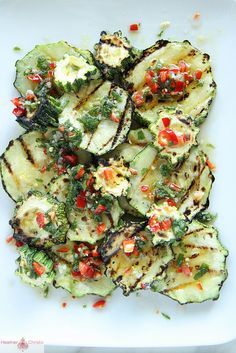 grilled zucchini with herbs and seasoning on a white square platter