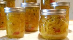 several jars filled with pickles sitting on top of a table