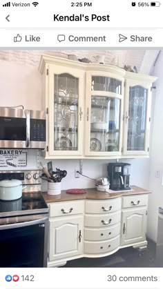 a kitchen with white cabinets and black stove top oven in the center, and an old fashioned microwave on the wall