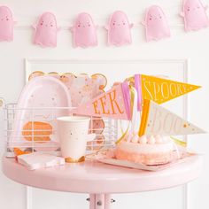 a pink table topped with plates and cups