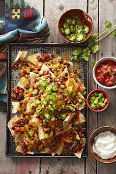 nachos on a tray with salsa and sour cream