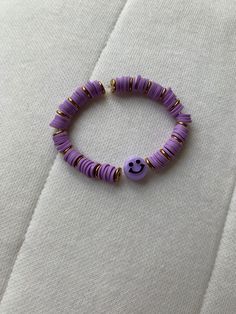 a purple beaded bracelet with a smiley face on it