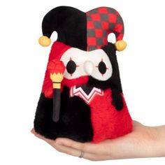 a hand holding a small stuffed animal in the shape of a pirate's hat