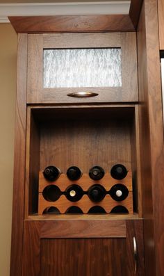 the wine rack is built into the wall with many bottles in it and there are no doors