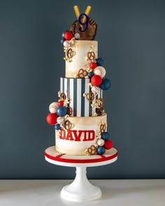 a three tiered cake is decorated with red, white and blue decorations on it