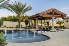 an outdoor pool surrounded by palm trees and water features a pergolated gazebo