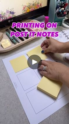 a woman is making post it notes on the desk