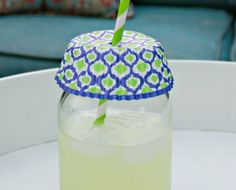 a green drink sitting on top of a white table next to a blue couch and chair