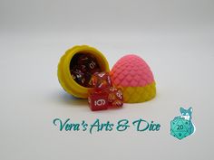 two dices in a yellow and pink container with the words vein's arts & dice