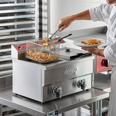 a man cooking food on top of a stove next to a fryer and oven