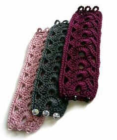 three crocheted headbands on a white surface, one is pink and the other is black