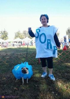 a woman standing next to a small dog wearing a shirt with the number 30 on it