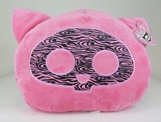 a pink stuffed animal with black and white designs on it's face is shown