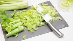 chopped celery on a cutting board next to a knife