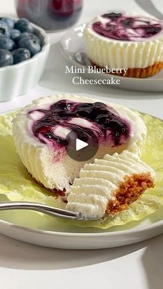 a dessert with blueberries and cheesecake on a yellow plate next to bowls of berries