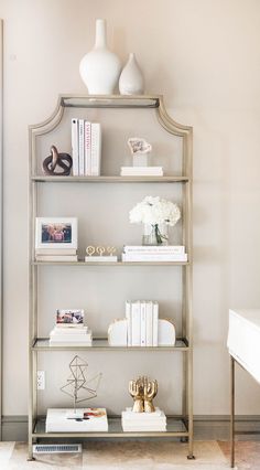 a shelf with books and vases on it