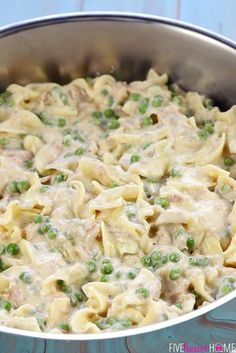 a pot filled with pasta and peas on top of a table