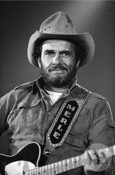 a black and white photo of a man with a guitar