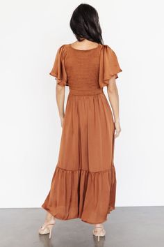 Our Lovell Smocked Midi Dress in Copper is a beautiful staple dress for your wardrobe! This pretty dress can be dressed up or dressed down! The perfect dress for any occasion! Midi Dress With Ruffle Sleeves For Brunch, Casual Midi Dress With Smocked Bodice And Flutter Sleeves, Flowy Ruched Smocked Top With Short Sleeves, Flowy Smocked Top With Ruched Short Sleeves, Flowy Smocked Top With Flutter Sleeves, Flutter Sleeve Midi Dress For Brunch, Smocked Bodice Midi Dress With Ruffle Sleeves For Brunch, Flowy Ruffle Sleeve Midi Dress, Flowy Smocked Midi Dress With Ruffle Hem