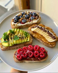 there are four different types of breads on the plate with berries and kiwi