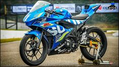 a blue motorcycle parked on top of a parking lot