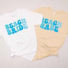 two t - shirts that say beach bride and the other one has blue letters on it