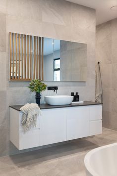 a bathroom with a sink, mirror and bathtub in it's center area