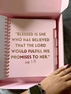 a woman's hand on top of a pink box with a bible in it