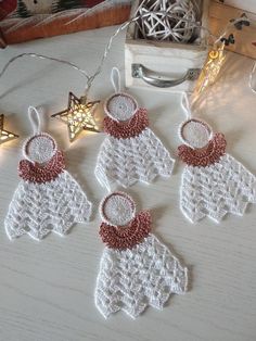 three crocheted christmas ornaments are sitting on a table next to some other decorations