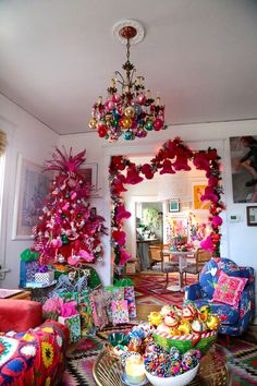 a living room filled with lots of presents under a chandelier