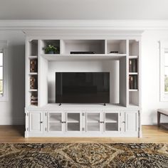 a white entertainment center with bookshelves and drawers in a living room setting,