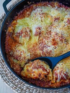 a casserole dish with meat and cheese in it on a wicker place mat