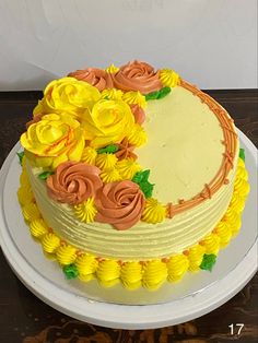 a cake with yellow and orange frosting flowers on it sitting on a white plate