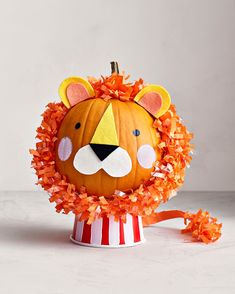 a lion pumpkin decorated with orange leaves