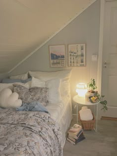 a bedroom with a bed, nightstand and pictures hanging on the wall next to it