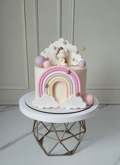 a white cake with pink, yellow and blue icing on top of a table