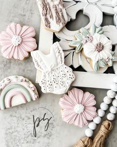 decorated cookies are displayed on a table with beads and tassels next to it