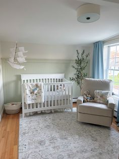 a baby's room with a crib, chair and rug