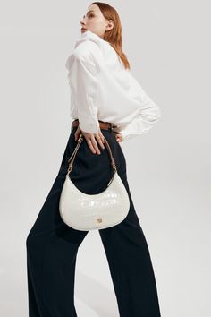 The Carrie Shoulder Bag features a gentle half-moon shape and slim, structured silhouette, offering a vintage-inspired look. The signature belt loop detail allows for the strap to be lengthened, making it perfect to carry on hand or use the shoulder strap for a hands-free style. Luxury Beige Modern Baguette Bag, Elegant Satchel Baguette Bag For Work, Classic Workwear Baguette Bag With Adjustable Strap, Classic Baguette Bag For Workwear With Adjustable Strap, Chic Top Handle Baguette Bag For Work, Chic Formal Baguette Bag With Round Handle, Elegant Top Handle Baguette Bag For Work, Elegant Crossbody Baguette Bag For Work, Elegant Baguette Crossbody Bag For Work