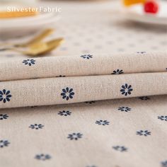 two pieces of fabric sitting on top of a table next to plates and utensils