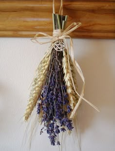 dried flowers hang from a wooden frame