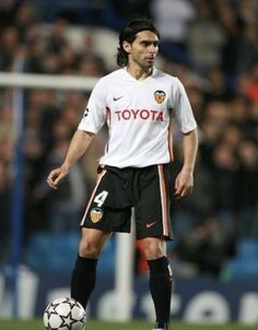 a man standing on top of a field with a soccer ball in front of him