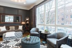 a living room filled with furniture and large windows