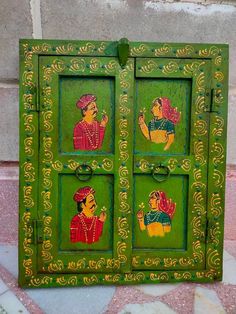 an old green painted cabinet with paintings on the front and side panels in different colors