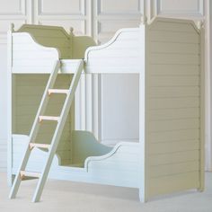 a white bunk bed with a ladder to the top and bottom, against a wall