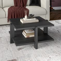 a coffee table with books on it in front of a couch