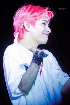 a man with pink hair and piercings on his arm