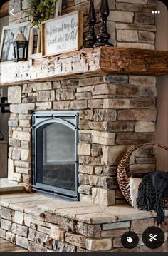 a stone fireplace in a living room with pictures on the mantle